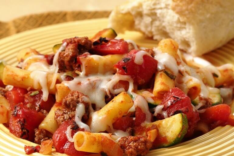 Pasta recipe with mince, diced tomatoes, zucchini, and onion topped with melted
