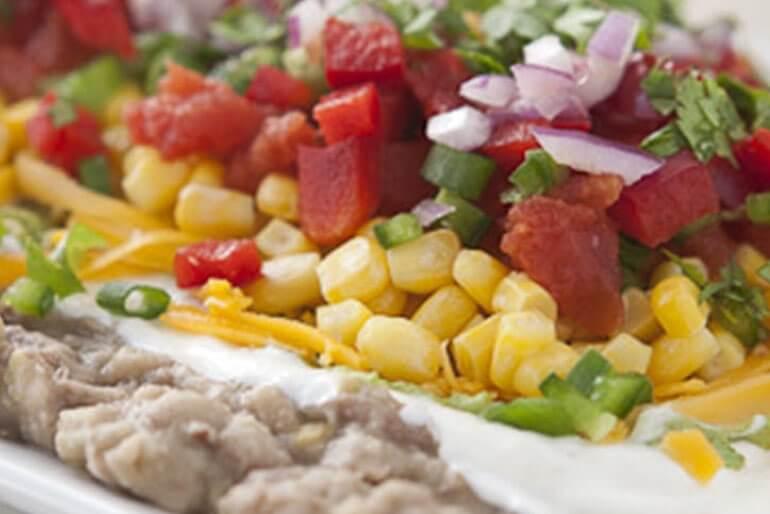 Full vegetable layered dip recipe with pinto beans, organic diced tomatoes, corn.