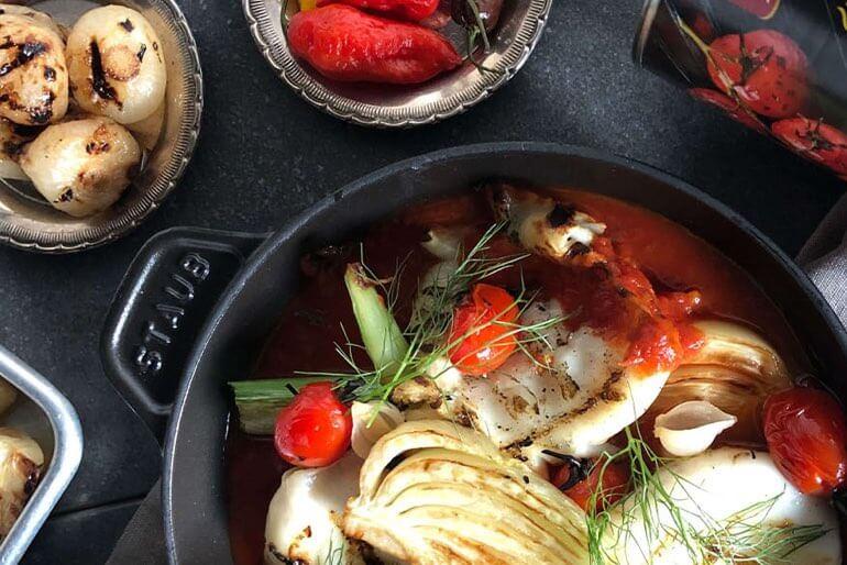 Recette de calamars braisés avec des tomates cerises grillées au feu, des poivrons cerises et de l'oignon jaune.
