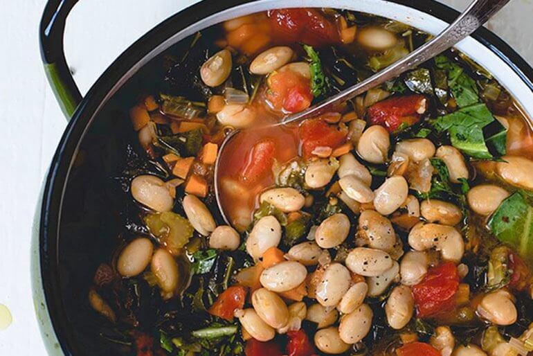 Recette de ragoût de chou vert et de haricots blancs à la tomate, avec du chou vert, des oignons jaunes, du céleri et des tomates en dés.