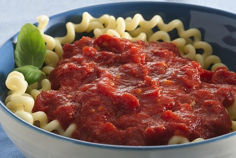 Arrabbiata sauce over pasta recipe, served in a white and blue bowl.