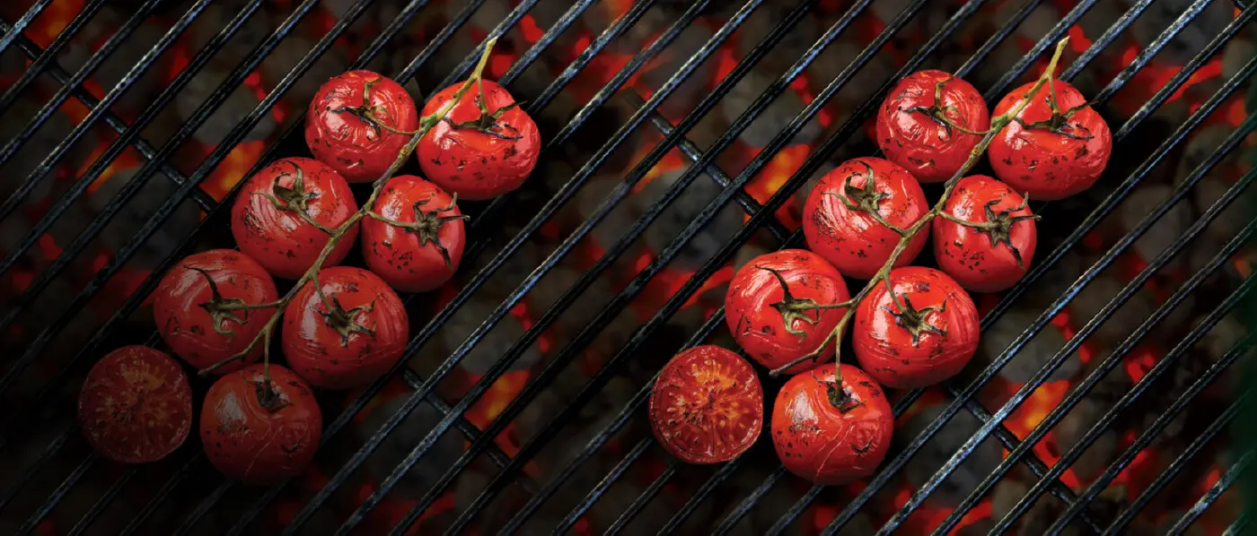 Vine tomatoes roasting over hot coal on a barbecue grill.